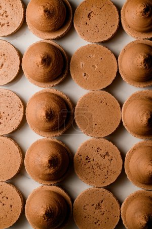 Macarons délicats appétissants de couleur brun clair avec remplissage crémeux sur une photo de démonstration vue du dessus