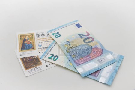 Téléchargez les photos : Image de billets de loterie nationale à côté de deux billets de 20 sur un fond blanc neutre - en image libre de droit
