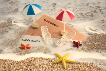 Téléchargez les photos : Composition pour les élections générales en été, parasols et chaises longues sur certaines enveloppes électorales qui s'enfoncent dans le sable sur la plage - en image libre de droit