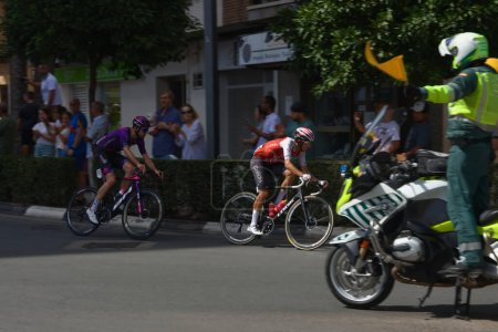 Téléchargez les photos : Deux cyclistes qui se sont échappés du peloton arrivent à un rond-point dans la ville valencienne de Torrent lors de l'étape 7 de la Vuelta 2023 d'Espagne. - en image libre de droit