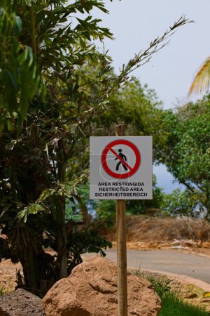 Téléchargez les photos : Gros plan d'un panneau qui délimite la zone réglementée dans un parc naturel en plusieurs langues, allemand, espagnol, anglais - en image libre de droit