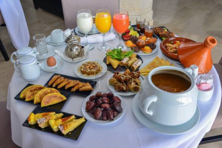 Foto de Moroccan breakfast in Ramadan. Harira soup. Dates, tea, juices and various sweets - Imagen libre de derechos