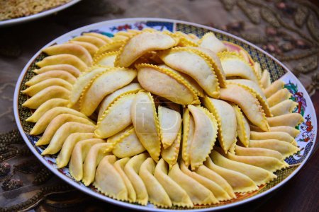 Hausgemachte Süßigkeiten aus Gazellenhörnern zum Ramadan. Detailaufnahme von frisch gebackenem Kaab El Ghazal, einer marokkanischen Süßigkeit, die auch als Gazellenhörner bekannt ist, Halal foo