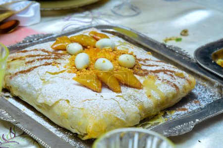 Gericht mit traditioneller marokkanischer Bastella gefüllt mit Hühnchen und garniert mit gebratenem Lachs