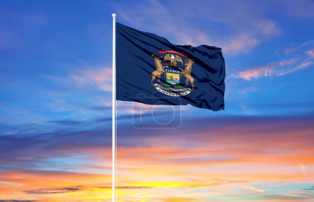 Photo for Michigan  flag on flagpoles and blue sk - Royalty Free Image
