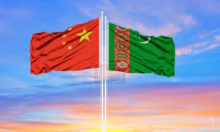 Téléchargez les photos : Drapeau de la Chine et du Turkménistan agitant dans le vent contre le ciel bleu nuageux blanc ensemble. Concept de diplomatie, relations internationales - en image libre de droit