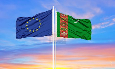 Téléchargez les photos : Union européenne et Turkménistan deux drapeaux sur les mâts et ciel nuageux bleu. Concept de diplomatie, relations internationales - en image libre de droit