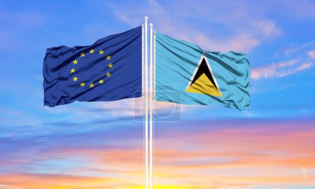 Photo for European Union and Saint Lucia two flags on flagpoles and blue cloudy sky . Diplomacy concept, international relations - Royalty Free Image