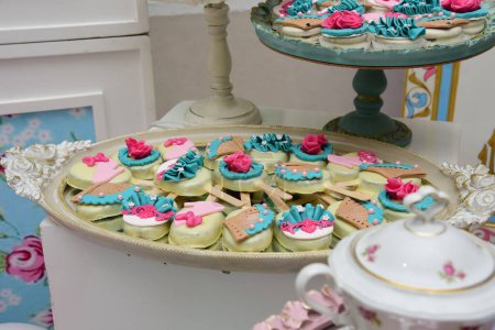 Foto de Pasteles y rosquillas brillantes y coloridos se colocan en una placa de doble nivel - Imagen libre de derechos