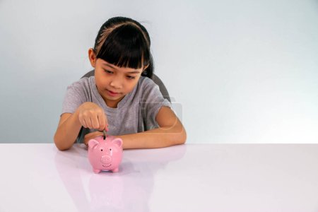 Photo for Adorable girl putting its savings in your money box - Royalty Free Image
