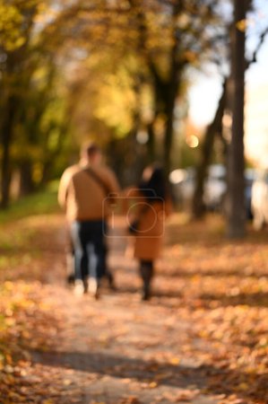Foto de Personas caminando en el parque de la ciudad. Hermosa temporada de otoño. Fondo borroso - Imagen libre de derechos