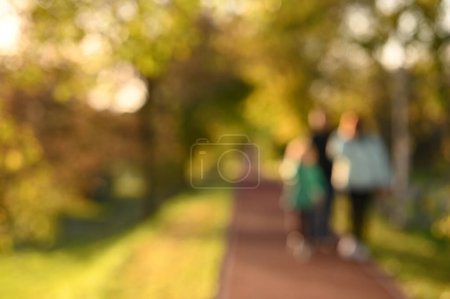 Téléchargez les photos : Les gens marchent au parc de la ville. Belle saison d'automne. Fond flou - en image libre de droit