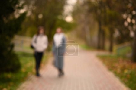 Téléchargez les photos : Vue floue des personnes marchant dans le parc de la ville - en image libre de droit