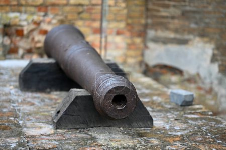 old cannon by brick wall outdoors 