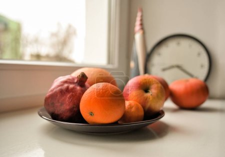 Foto de Naturaleza muerta con juguete de santa claus, calabazas y frutas en el alféizar de la ventana - Imagen libre de derechos