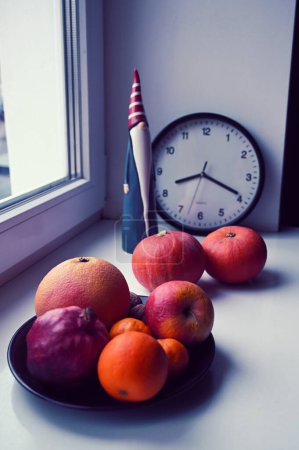 Foto de Naturaleza muerta con juguete de santa claus, calabazas y frutas en el alféizar de la ventana - Imagen libre de derechos