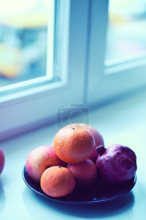 Téléchargez les photos : Fruits frais près d'une fenêtre sur le rebord de la fenêtre - en image libre de droit