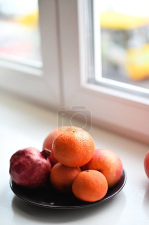 Téléchargez les photos : Fruits frais près d'une fenêtre sur le rebord de la fenêtre - en image libre de droit