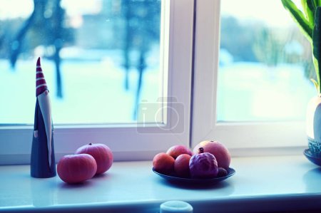 Photo for A plate of fruits, pumpkins   and santa claus figure  on windowsill - Royalty Free Image