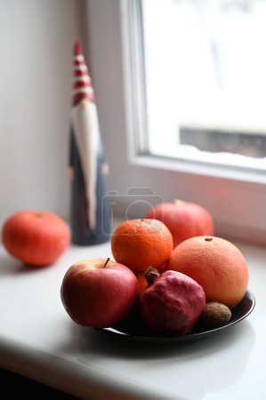 Photo for Still life with santa claus toy,  pumpkins and fruits  on windowsill - Royalty Free Image