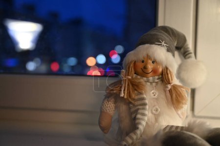Photo for Christmas toy girl in santa claus hat  on windowsill - Royalty Free Image