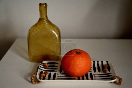 Foto de Botella de naranja fresca y vacía en el alféizar de la ventana - Imagen libre de derechos