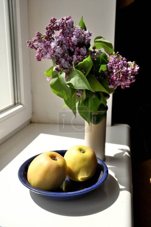 Téléchargez les photos : Bouquet de belles fleurs lilas en vase et pommes - en image libre de droit