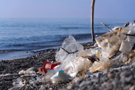 Photo for Close-up of a pile of garbage, cellophane on a pebble beach at sea on a sunny day. Concept of environmental pollution, environmental disaster - Royalty Free Image