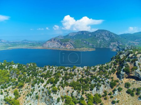 Drone view of the Dalyan River and mountains in the vicinity of Iztuzu Beach, Turtle Beach on a sunny day, Turkey. Beautiful mountain landscape with a river around the mountains summer day