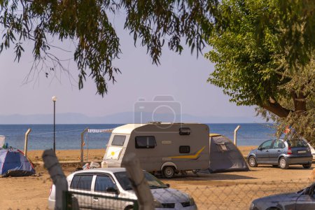 Anhänger für ein Wohnmobil am Strand auf einem ausgestatteten Campingplatz. Auto für unterwegs. Anhänger mit Schlafplatz.