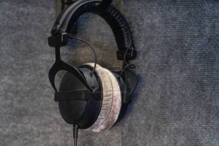 Téléchargez les photos : Gros plan sur les écouteurs professionnels modernes accrochés au mur dans le studio d'enregistrement - en image libre de droit
