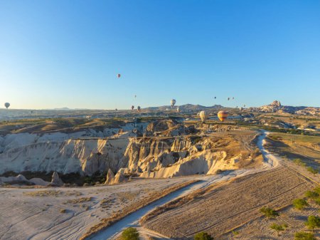 Téléchargez les photos : Des ballons colorés survolent la vallée des fabuleuses cheminées de Nevsehir, Goreme, Cappadoce, Turquie. Vue panoramique à couper le souffle depuis un drone en Cappadoce, tourisme en montgolfière. - en image libre de droit