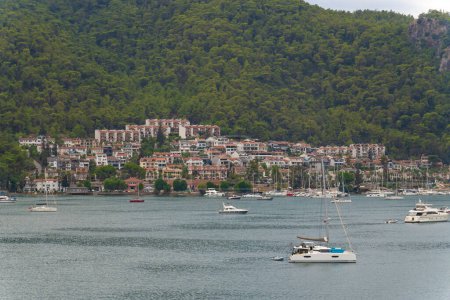 Téléchargez les photos : Vue sur la baie de Fethiye avec yachts, maisons, montagnes par temps nuageux, Turquie - en image libre de droit