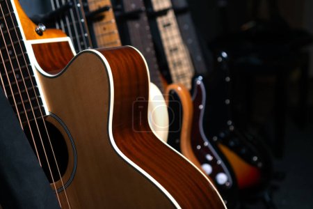 Téléchargez les photos : Gros plan de belles guitares debout dans une rangée près du mur dans un studio de musique ou dans un magasin, mise au point sélective. - en image libre de droit