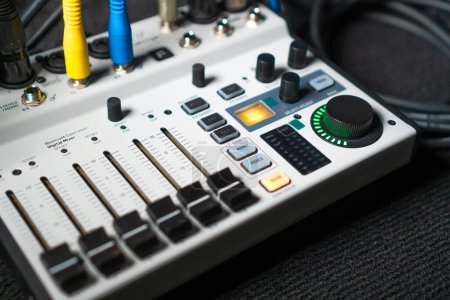 Nahaufnahme eines von Hand einstellbaren Mischpultknopfs zur Lautstärkeregelung während der Live-Studioaufführung. Mixer verfügt über mehrere Knöpfe und Tasten für präzise Audio-Mix-Anpassungen.