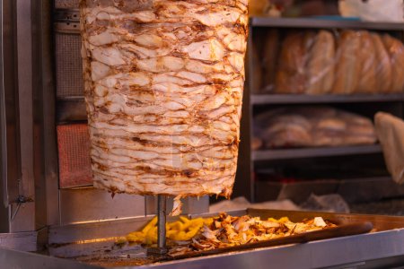 Téléchargez les photos : Gros plan de la viande grillée sur un gril vertical est utilisé dans le kebab ou le shawarma traditionnel donateur de nourriture de rue - en image libre de droit