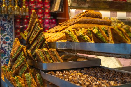 Téléchargez les photos : Gros plan sur la délicieuse baklava sucrée turque aux pistaches vertes et autres bonbons turcs sur le comptoir. - en image libre de droit