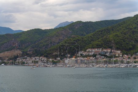Téléchargez les photos : Vue sur la baie de Fethiye avec yachts, maisons, montagnes par temps nuageux, Turquie - en image libre de droit