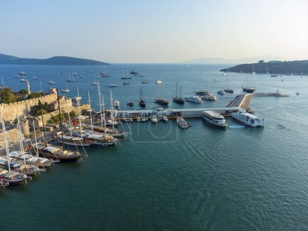 Téléchargez les photos : Superbe vue sur le magnifique port rempli de yachts de Bodrum et l'ancien château de Kalesi dans la province de Mugla en Turquie au coucher du soleil. - en image libre de droit