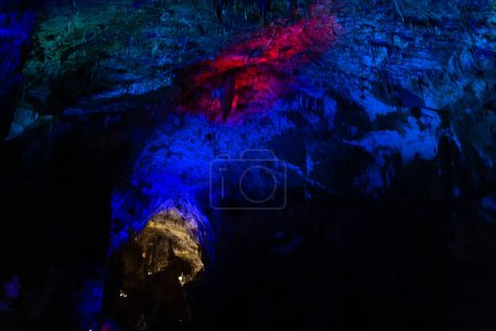 Téléchargez les photos : Grotte karstique Prométhée, illuminée par des lumières colorées, des stalactites et des stalagmites. - en image libre de droit