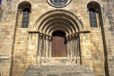 Téléchargez les photos : Coimbra, Portugal - 15 août 2022 : Gros plan de l'entrée de l "église St Tiago montrant une porte ornée avec porte en bois, plusieurs arches et fenêtres en pierre - en image libre de droit