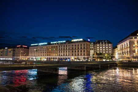 Photo for Geneva, Switzerland - August 30 2023: Rhone River and scenic view of building facades in the city of Geneva illuminated at night in Geneva in Switzerland - Royalty Free Image