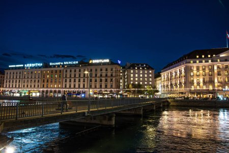 Téléchargez les photos : Genève, Suisse - 30 août 2023 : Fleuve Rhône et vue panoramique sur les façades des bâtiments de la ville de Genève illuminées la nuit à Genève en Suisse - en image libre de droit