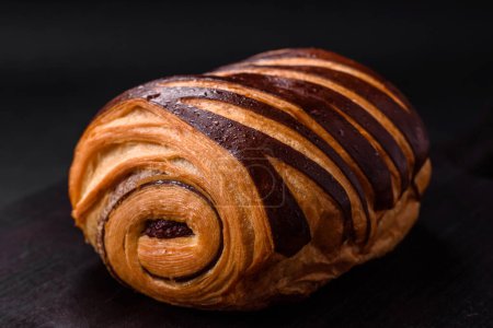 Photo for Delicious sweet crispy fresh baked cinnamon bun on dark concrete background - Royalty Free Image