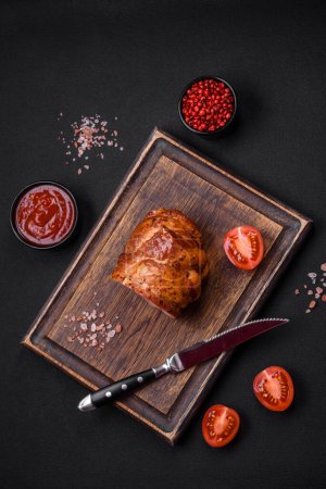 Téléchargez les photos : Délicieux rouleau de viande fraîche cuite au four avec des épices et des herbes sur un fond de béton foncé - en image libre de droit