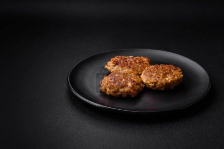 Photo for Delicious fresh fried minced fish cutlets with spices and herbs on a dark concrete background - Royalty Free Image