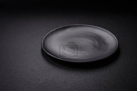 Photo for Bumpy empty ceramic plate on a textured concrete background. Kitchen utensil item - Royalty Free Image