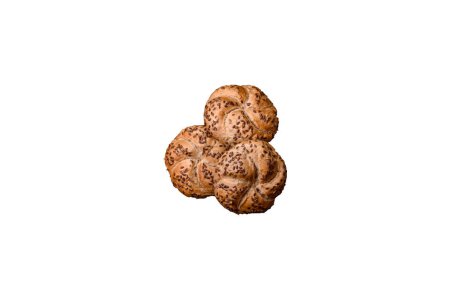 Téléchargez les photos : Délicieux pain croustillant fraîchement cuit ou rouleau de kaiser avec des graines de sésame sur fond de béton foncé - en image libre de droit