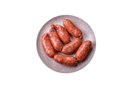 Photo for Baked chicken or pork sausages, salt, spices and herbs on a dark concrete background - Royalty Free Image