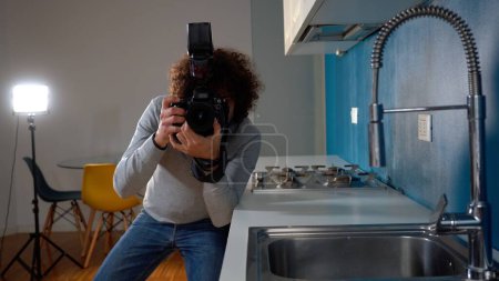 Photographer man taking pictures and video in apartment - real estate home photoshoot for selling house whit professional estate agency - home staging and enhance the property for advertising
